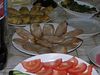Beth > The spread of side dishes / hors d'oeuvres at the Seder in Zvinagorodka.  I took this picture because we thought it was pretty amazing that they were serving pork at a Pesach seder, but it turns out it was chicken sausage.